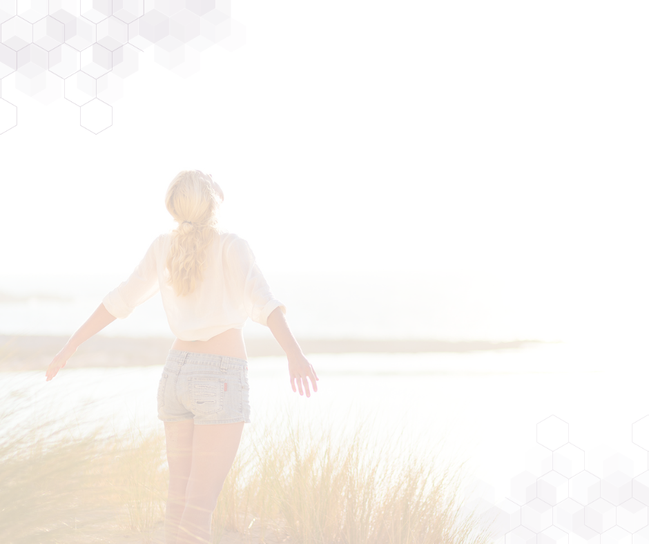 woman standing on beach arms extended in freedom